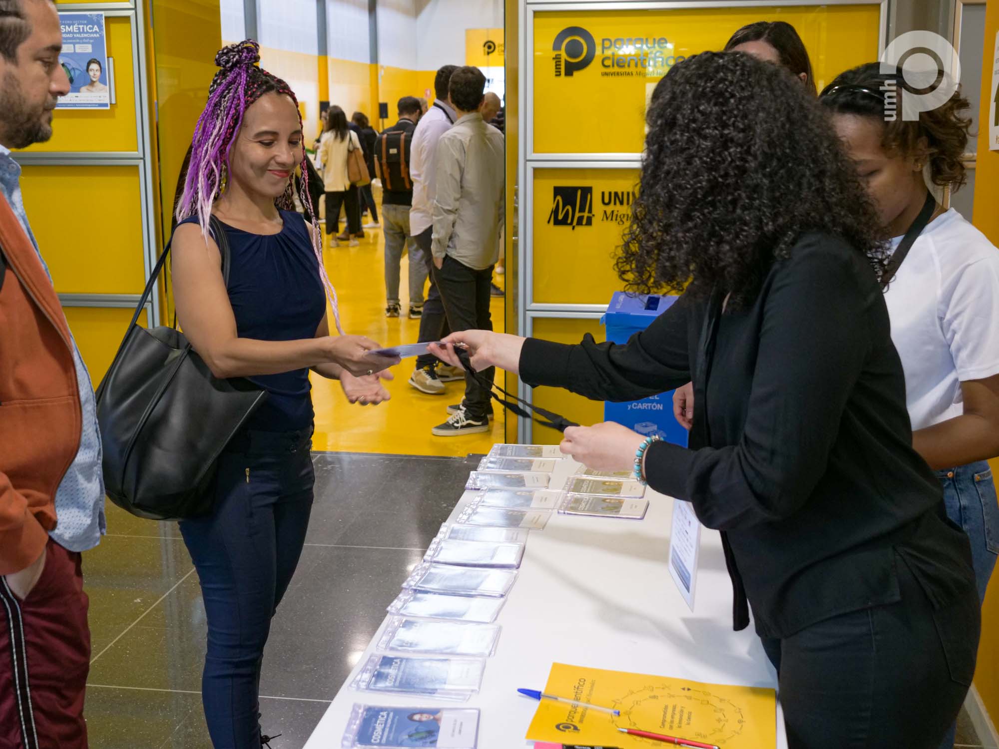 Asistente recoge su acreditación para acceder al evento